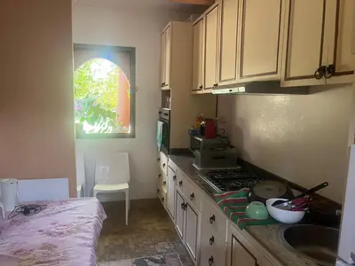 a kitchen with white cabinets and a sink and a counter at Marrakech 2 in Marrakech