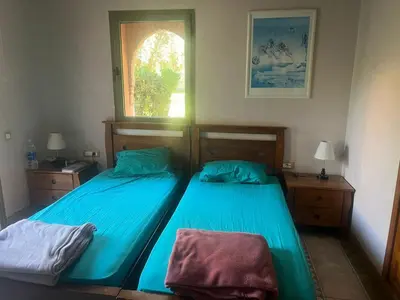 a bedroom with two beds with blue sheets and a window at Marrakech 2 in Marrakech