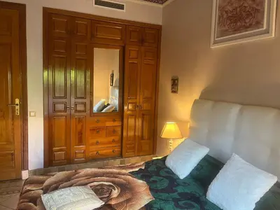 a bedroom with a bed and a lamp and a mirror at Marrakech 2 in Marrakech