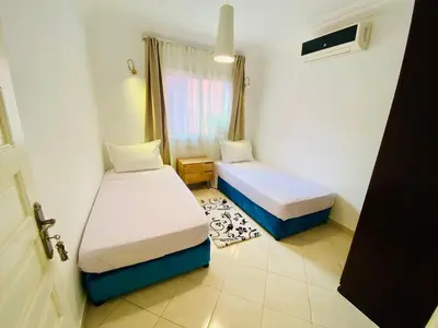 a small room with two beds and a window at Appart Moderne Calme & Climatisé in Marrakech
