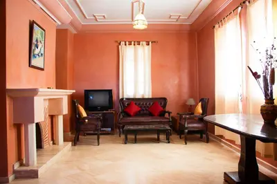 a living room with a couch and chairs and a television at Villa 36 Amelkis - Pool & Garden in Marrakech