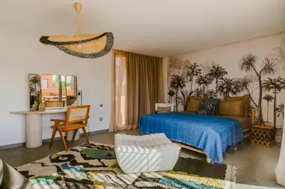 a bedroom with a bed with a blue comforter at Villa - Piscine chauffée sur demande et gouvernante in Marrakech
