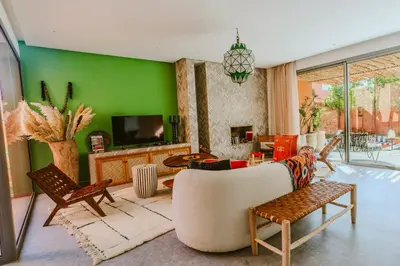 a living room with a green wall at Villa - Piscine chauffée sur demande et gouvernante in Marrakech
