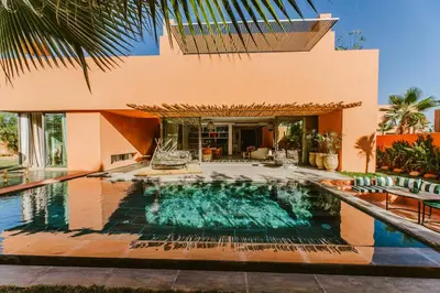 a house with a swimming pool in front of a house at Villa - Piscine chauffée sur demande et gouvernante in Marrakech