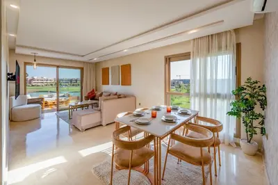 a living room with a table and chairs and a couch at Luxury and serenity in Prestigia Golf & Pool in Marrakech