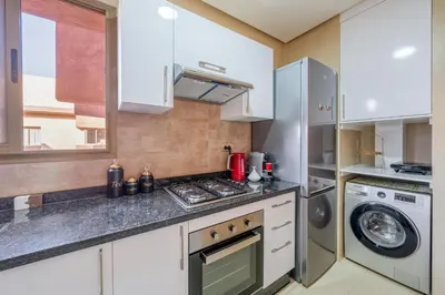 a kitchen with a stove and a washer and dryer at Luxury and serenity in Prestigia Golf & Pool in Marrakech