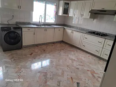 a kitchen with white cabinets and a washer at Élégance et authenticité in Marrakech