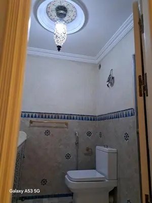 a bathroom with a toilet and a chandelier at Élégance et authenticité in Marrakech