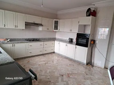 a kitchen with white cabinets and a tile floor at Élégance et authenticité in Marrakech