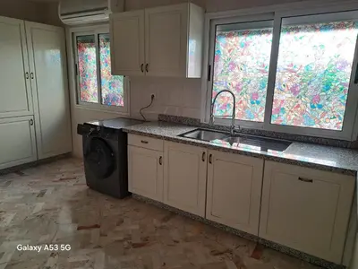 a kitchen with a sink and a washing machine at Élégance et authenticité in Marrakech