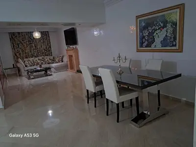 a living room with a dining room table and chairs at Élégance et authenticité in Marrakech