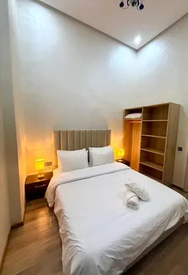 a bedroom with a large bed with white sheets at Appartement sympathique in Marrakech