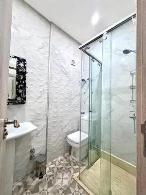 a bathroom with a glass shower with a toilet at Appartement sympathique in Marrakech