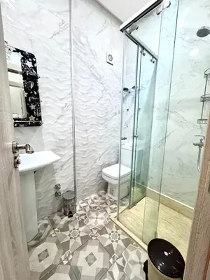 a bathroom with a shower and a toilet and a sink at Appartement sympathique in Marrakech