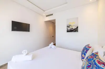 a room with a bed and a tv on the wall at Appartement haut standing au centre de Marrakech in Marrakech
