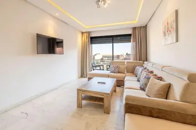 a living room with a couch and a tv at Appartement haut standing au centre de Marrakech in Marrakech
