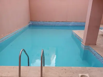 a swimming pool with blue water in a building at Sunshein in Marrakech