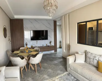 a living room with a table and a couch at Le Marrakchi - 2 chambres - Parking - Wifi in Marrakech
