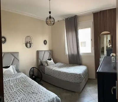 a bedroom with two beds and a mirror at Le Marrakchi - 2 chambres - Parking - Wifi in Marrakech