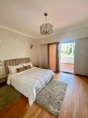 a large bedroom with a large white bed and a chandelier at Apartment in Marrakech equipped and comfortable in Marrakech