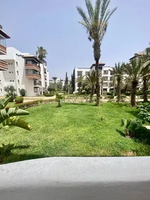 a green park with palm trees and buildings at Apartment in Marrakech equipped and comfortable in Marrakech