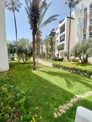 a park with palm trees and a building at Apartment in Marrakech equipped and comfortable in Marrakech