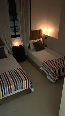 two beds in a hotel room with lights on at Etoile rouge in Marrakech