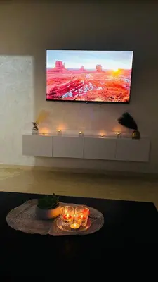 a living room with a tv and a table with candles at Etoile rouge in Marrakech