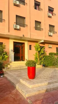 a red pot sitting in front of a building at Etoile rouge in Marrakech