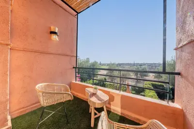 a balcony with chairs and a table and a view at Villa Waky Confort & Relax in Marrakech