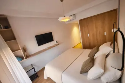 a small room with a bed and a tv at Appartement Moderne, Vue Atlas & Piscine, Noria in Marrakech