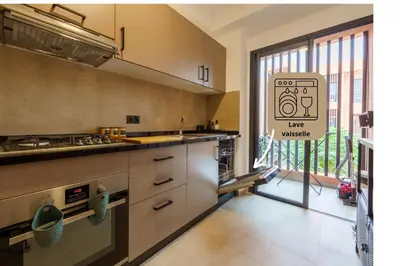 a kitchen with a sink and a large window at Appartement Moderne, Vue Atlas & Piscine, Noria in Marrakech
