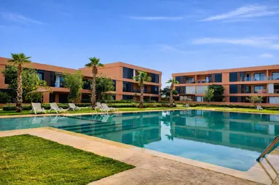 a swimming pool in front of a building at Appartement Moderne, Vue Atlas & Piscine, Noria in Marrakech
