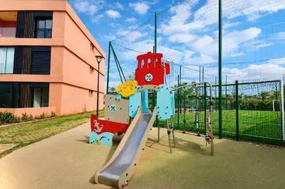 a playground with a slide in front of a building at Appartement Moderne, Vue Atlas & Piscine, Noria in Marrakech