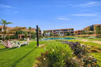 a resort yard with a swimming pool and a building at Appartement Moderne, Vue Atlas & Piscine, Noria in Marrakech