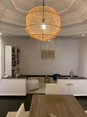 a living room with a table and a chandelier at Appartement au cœur de Marrakech in Marrakech
