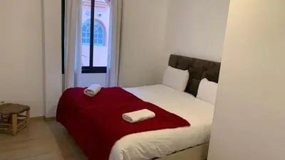a bedroom with a bed with a red blanket at Appartement au cœur de Marrakech in Marrakech