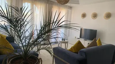 a living room with a blue couch and a plant at Appartement au cœur de Marrakech in Marrakech