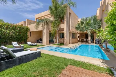 a villa with a swimming pool in a yard at Villa sur golf avec piscine privée chauffée in Marrakech