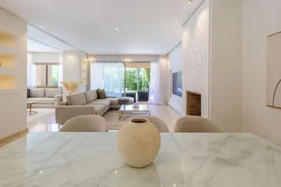 a living room with a table and a couch at Villa sur golf avec piscine privée chauffée in Marrakech