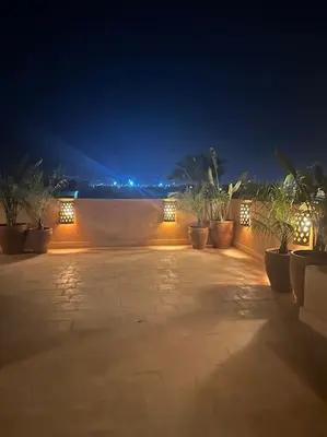 a patio at night with potted plants and lights at Villa sur golf avec piscine privée chauffée in Marrakech