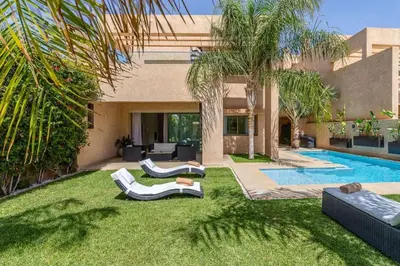 a yard with two lounge chairs and a swimming pool at Villa sur golf avec piscine privée chauffée in Marrakech