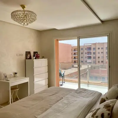 a bedroom with a bed and a desk and a window at Appartement Centre Gare gueliz chic et cosy de Marrakech in Marrakech