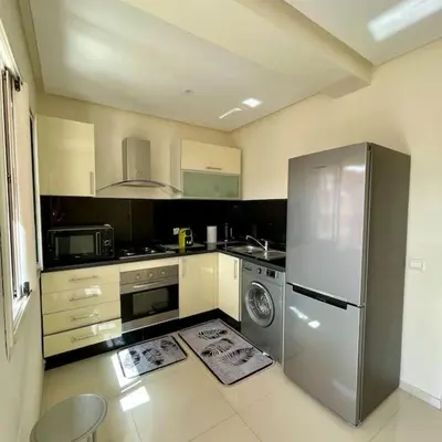 a kitchen with a stainless steel refrigerator and a dishwasher at Appartement Centre Gare gueliz chic et cosy de Marrakech in Marrakech
