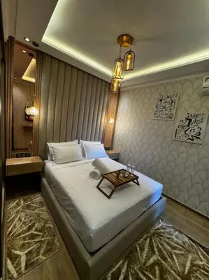 a bedroom with a bed with a table on it at Appartement confort in Marrakech
