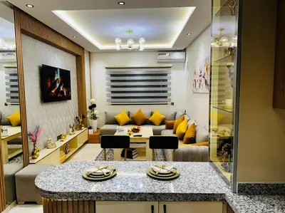 a living room with yellow pillows and a couch at Appartement confort in Marrakech
