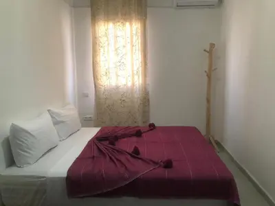 a bedroom with a bed with a red blanket on it at Riad Nomad House Marrakech in Marrakech