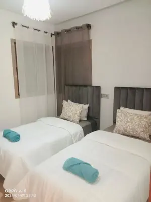 a bedroom with two beds with blue towels on them at Appartement de vacances à Prestigia golf city rez jardin in Marrakech