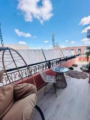 a balcony with a couch and a table on a roof at Magnifique 1 Room WIFI en plein coeur de GUELIZ in Marrakech