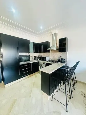 a kitchen with black cabinets and a counter top at Magnifique 1 Room WIFI en plein coeur de GUELIZ in Marrakech